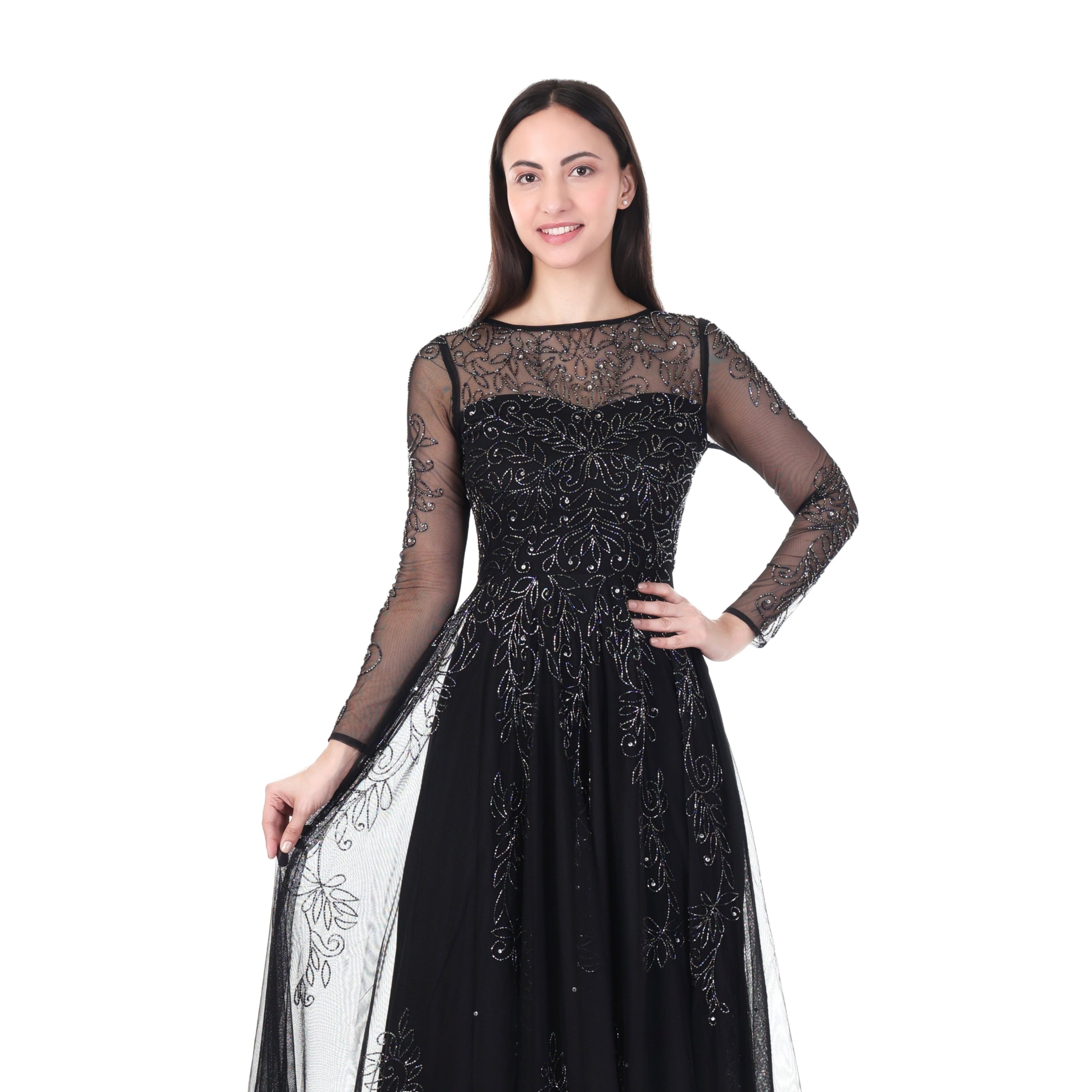 Woman wearing a black evening gown with sheer sleeves on a white background